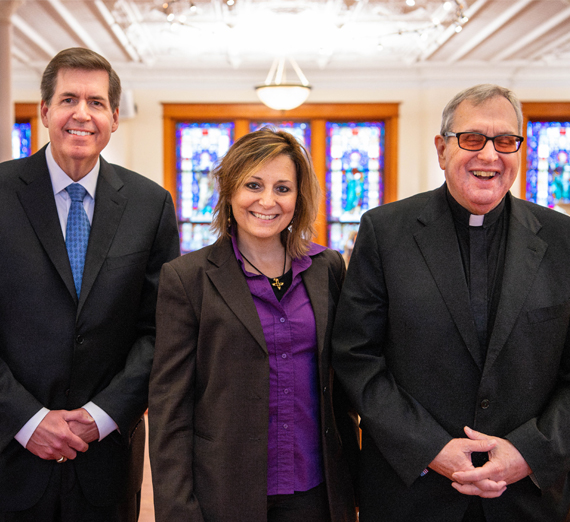 Une femme en toge et coiffe de graduation sourit à la caméra